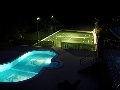 Pool and tennis court at night